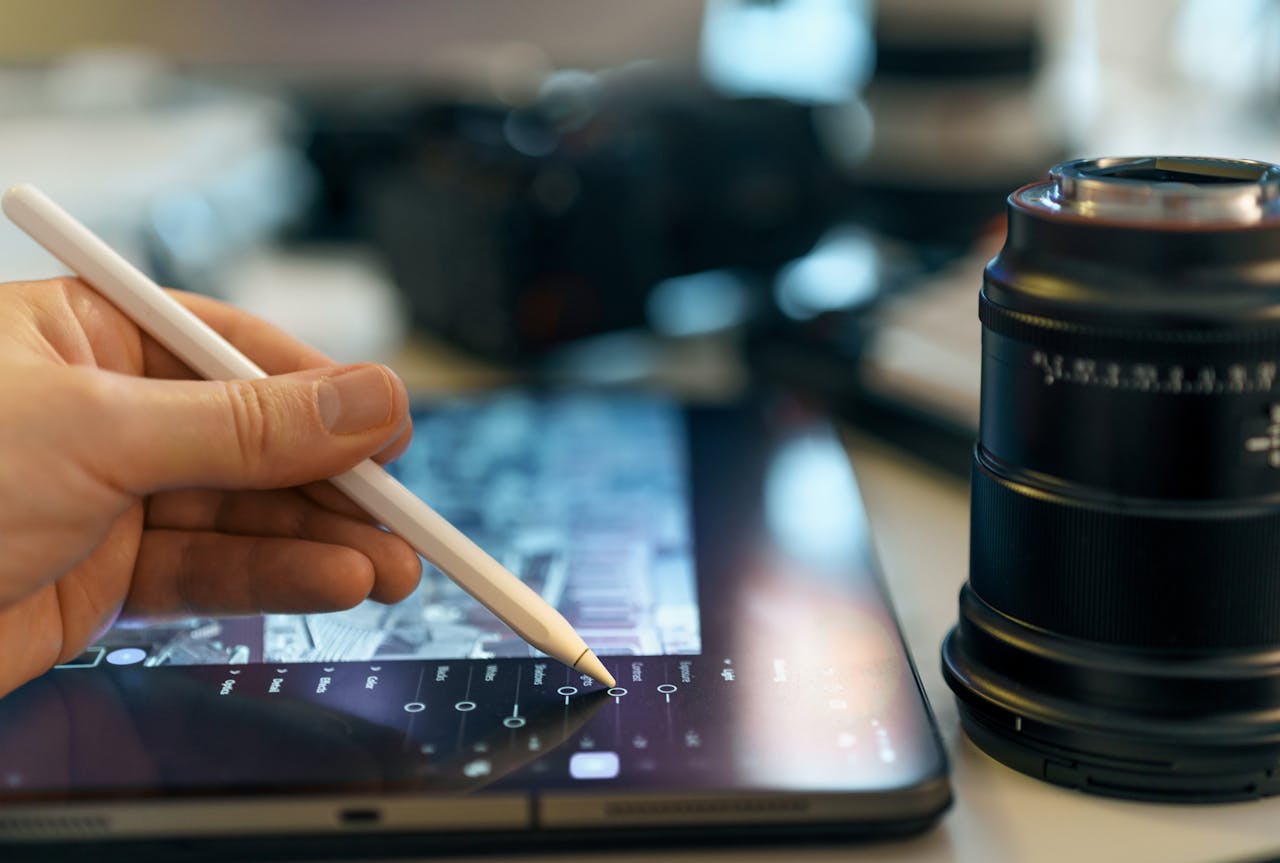 Closeup of a digital artists hand using a stylus on a graphics tablet in a creative workspace.
